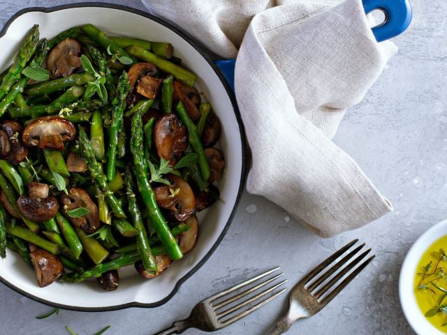 Asparagus and mushrooms sauteed in a cast iron pan with lemon zest